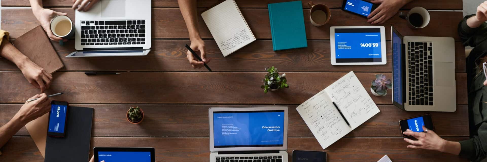 Team working together in an office with computers and devices