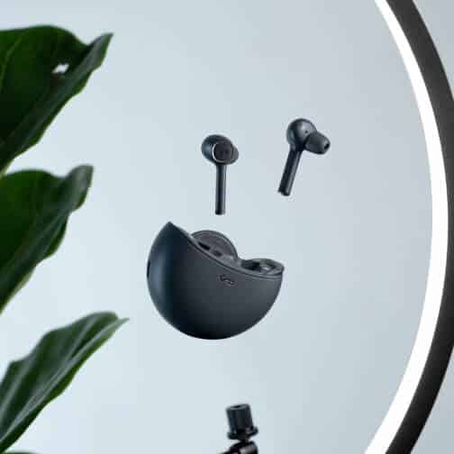 Black wireless earphones on a white desk